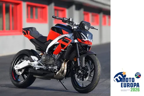 Moto di colore rosso e nero marca Aprilia Tuono 457 in posizione frontale laterale