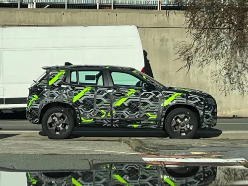 Jeep Avenger 2027 camuffato di colore grigio e verde flash in posizione laterale parcheggiato