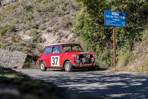 La Austin Mini Cooper S del 1964 che vinse il Rallye di MonteCarlo 1964 a fianco del cartello che indica il Col de Turini, nelle montagne sopra il Principato di Monaco