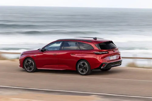 Una vista posteriore della Peugeot 308 2026 SW di tre quarti, con dietro il mare