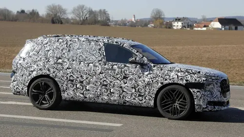 Nell'immagine spia si vede il nuovo Q9 di Audi visto di lato su una strada pubblica