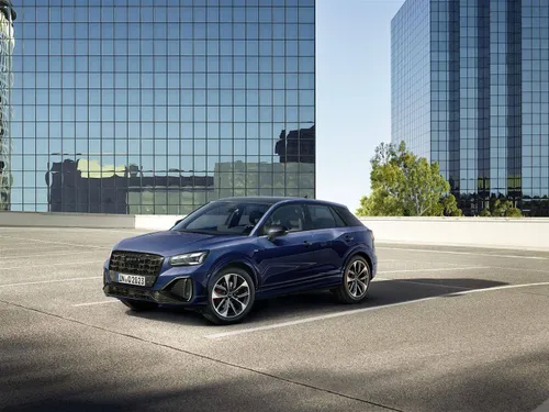 audi q2 di colore blu parcheggiata con i grattacieli alle spalle