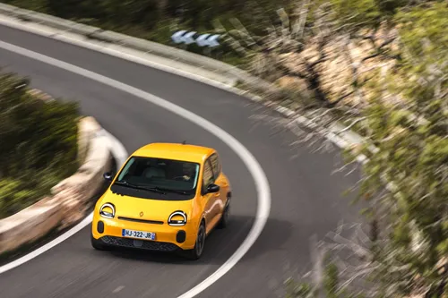 La nuova Renault Twingo 2026 IV E-Tech Giallo Mango impegnata in una curva ad alta velocità tra le strade di Ibiza&nbsp;