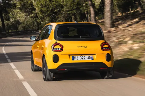 La nuova Renault Twingo 2026 IV E-Tech Giallo Mango fotografata nel posteriore su una strada statale alberata