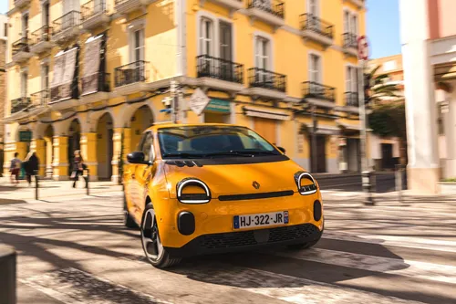 La nuova Renault Twingo 2026 IV E-Tech Giallo Mango fotografata dall'anteriore mentre svolta in una via cittadina di Ibiza