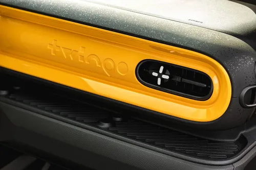 Un dettaglio del logo della plancia della Renault Twingo 2026 nel pannello davanti al passeggero verniciato in Giallo Mango