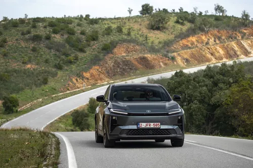 Il frontale della Toyota C-HR+ 2026 impegnata in una curva di una strada statale tortuosa&nbsp;