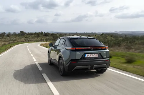 Il posteriore della Toyota C-HR+ 2026 impegnata in una curva di una strada statale tortuosa