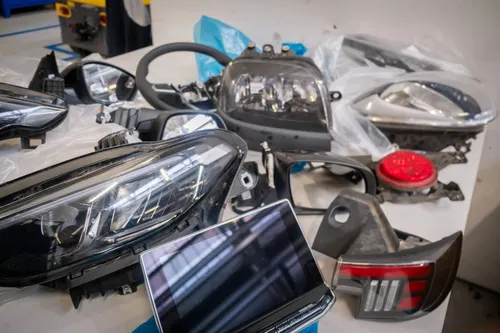 si vedono pezzi di auto come fari schermi e altre componenti che verranno riutilizzate come pezzi di ricambio per altri modelli