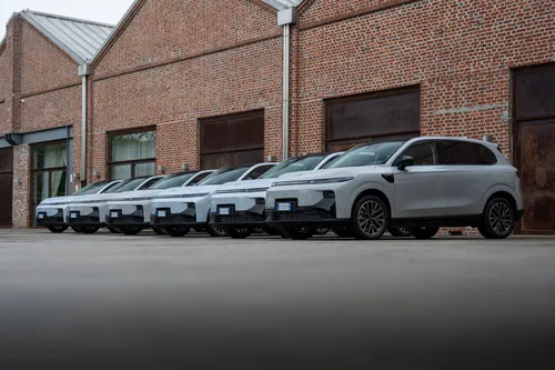 Diversi modelli di Leapmotor B10 REEV parcheggiati con dietro un muro di mattoni a vista