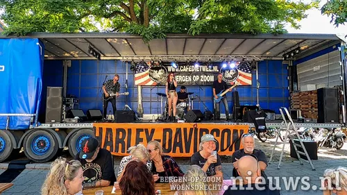 De 'moddervette' rockband Motherfat op de podium trailer op het plein voor het café