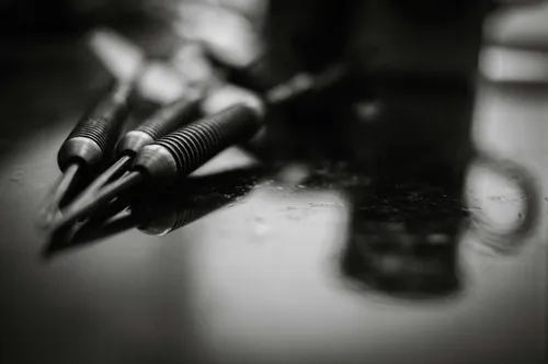 a-black-and-white-photo-of-pens-and-a-cell-phone-