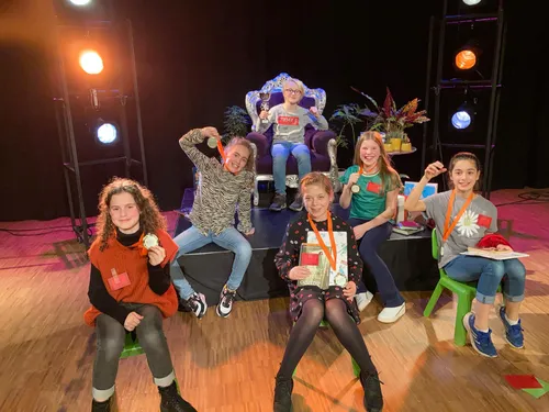 winnaar luuk de kok op voorleesstoel temidden van de vijf andere finalisten