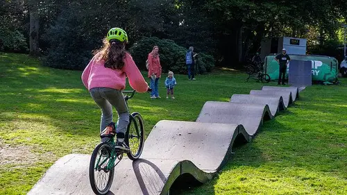 Een jonge fietser rijdt over de zogeheten pump track.