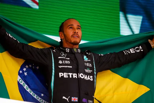 Lewis Hamilton auf dem Podium mit der brasilianischen Flagge nach seinem Sieg beim Großen Preis von São Paulo 2021, nachdem er von P10 gestartet war – Foto: Race Pictures