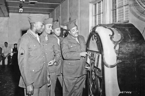 first of the famous mills brothers quartet to enter army service pvt harry mills stops at the jukebox in the receptio nara 531178