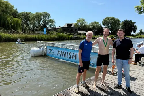 wethouder sport van de gemeente alkmaar christiaan peetoom reikt medaille uit aan deelnemer