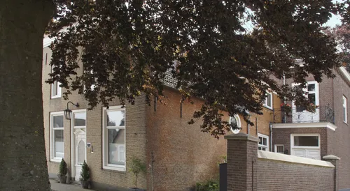 Aanzicht van de westelijke zijgevel, de achteraanbouw en de scheidingsmuur