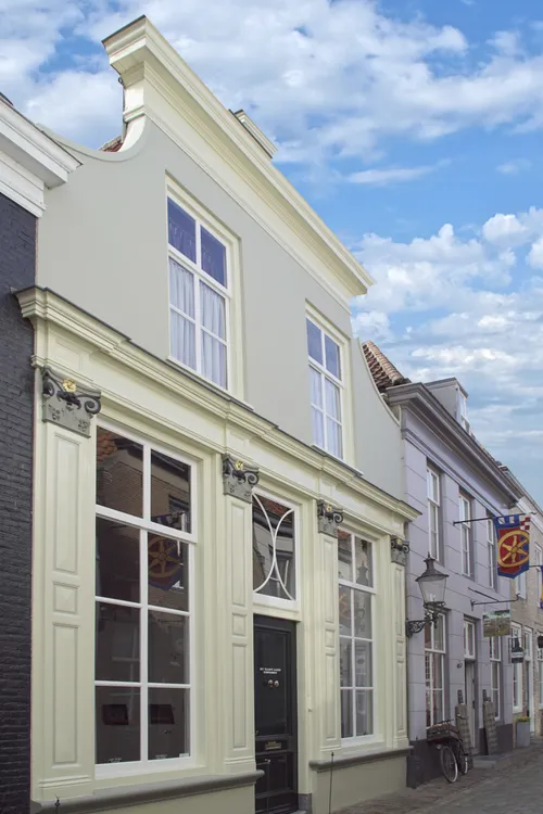 Afbeelding van de noordelijke gevelwand van de Engstraat. Het pand 14 heeft een hoge winkelpui met vier pilasters