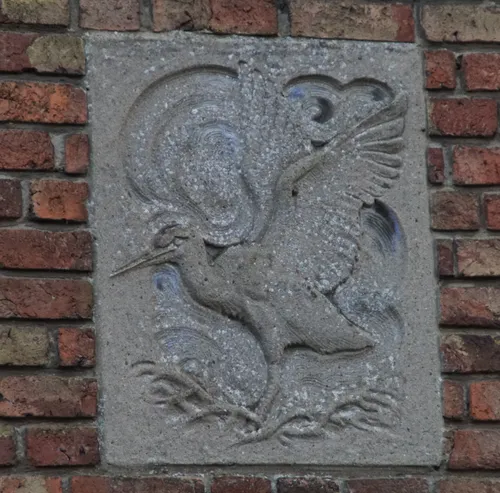 De gevelsteen met het reliëf van een ooievaar, landend op een nest