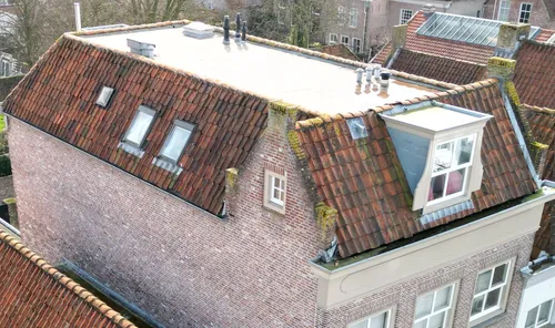 Aanzicht van het samengestelde dak, bestaande uit een platdak, drie schilddaken en een zadeldak