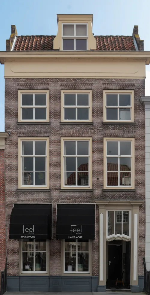 Vooraanzicht van het pand, waarbij de winkelruimte nu een kapsalon en nagelstudio is