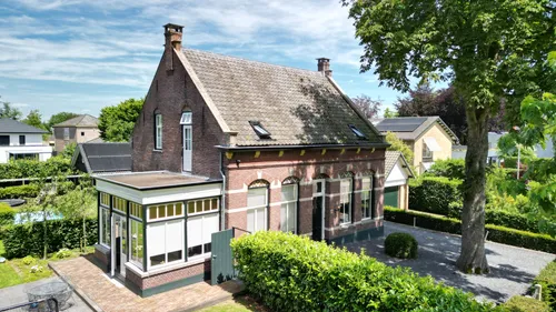 Vooraanzicht
van de woning met veranda, een gemeentelijk monument