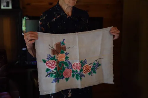 A. Bunikienė rodo rankdarbį, kurį sukūrė tremtyje. Karolinos Vilkelienės nuotr.