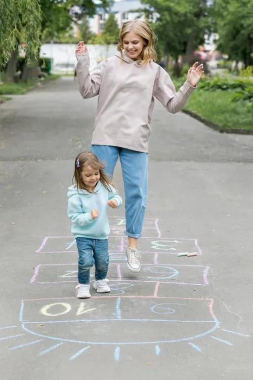 mother and cute child playing hopscotch 683x1024