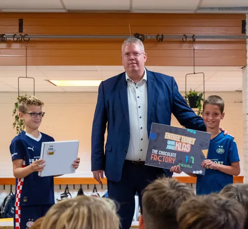 Wethouder J. van Gerwen overhandigt ticket voor The Chocolate Factory