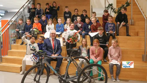 221216 stadspenning voor marieke van soest met burgemeester gerard renkema haar tribike en leerlingen maranthaschool 2