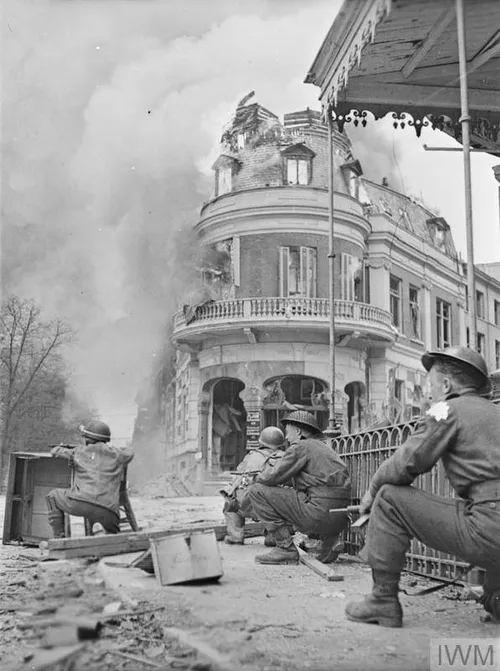 Britse militairen zoeken dekking bij een pand aan de Oude Kraan tijdens Operatie Anger. Op de achtergrond staat bakkerij Van der Velden