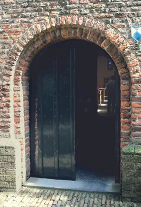 romaanse boog met toegangsdeur in de toren uit 1200