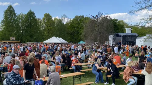 Drukte in het stadspark bij het podium achter de voormalige entree van het oude zwembad.