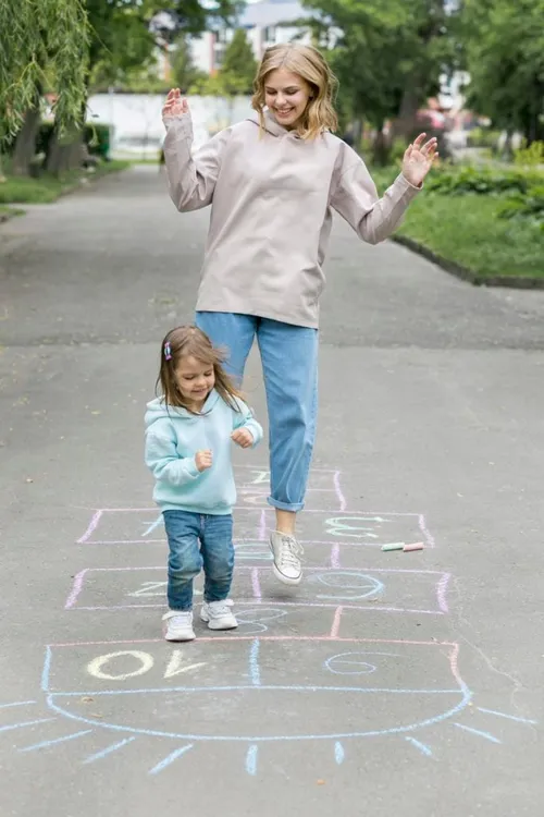 mother and cute child playing hopscotch 683x1024
