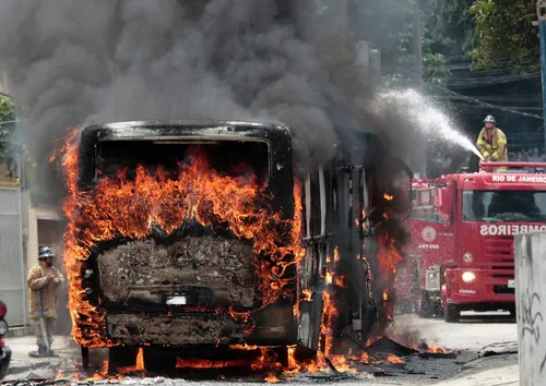 a firefighter attempts to extinguish a burning bus