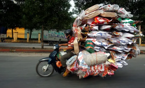 a man transports paper replicas of various items to be sold for the vu lan festival festival of hungry ghosts outside hanoi vietnam