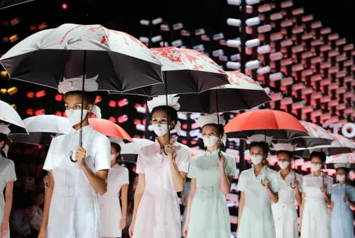 models wearing masks hold umbrellas as they perform during the toray liu wei collection segment at china fashion week in beijing on oct 30