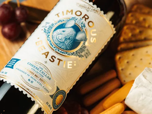 De Douglas Laing Timorous Beastie Scheese Cellar Collection 3 whisky dichtbij op een plankje met kaas en crackers