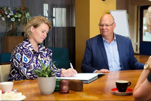 Wethouder Twan van Bronkhorst (r) en directeur Leonie Meuwszen van BINX ondertekenen het contract voor verduurzaming en renovatie van ’t Mozaïek.