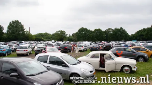 Een vol geparkeerd evenementen terrein tegenover de kerk
