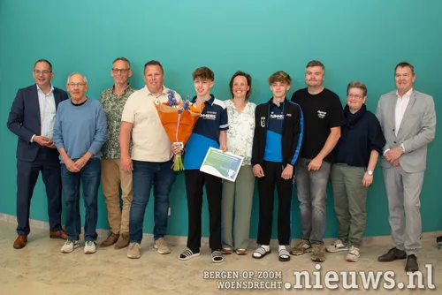 Tom tussen zijn ouders, broer en trainers em de burgemeester en wethouder