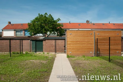Een ruime achtertuin met fietsenschuurtje