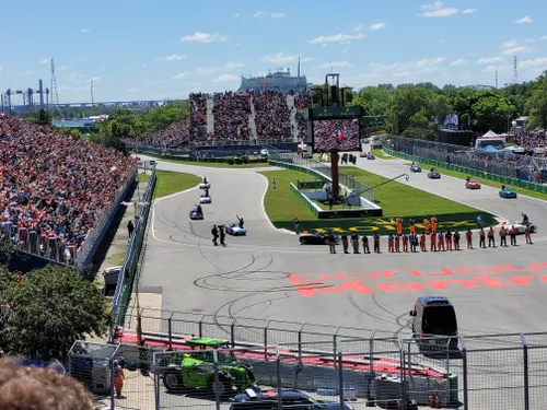<i>De Drivers' Parade bestaat uit oldtimers die F1-coureurs het circuit rondrijden. Elke oldtimer heeft aan de voorkant een vlaggetje die correspondeert met de nationaliteit van de coureur.</i>