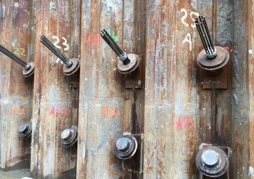 Strengankers zijn ankers die door de damwand heen steken en schuinweg diep de grond in gaan om de bovenzijde van de damwand op zijn plek te houden als de tunnelbak wordt uitgegraven. Bron: Boskalis
