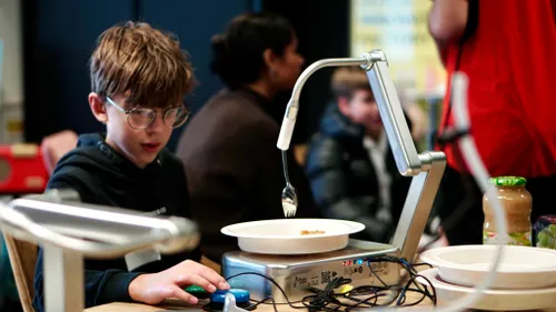 foto 2 scholier probeert eten met robotarm uit 2