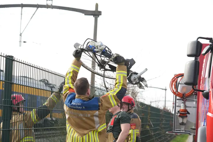 Fiets wordt voor trein gegooid.
