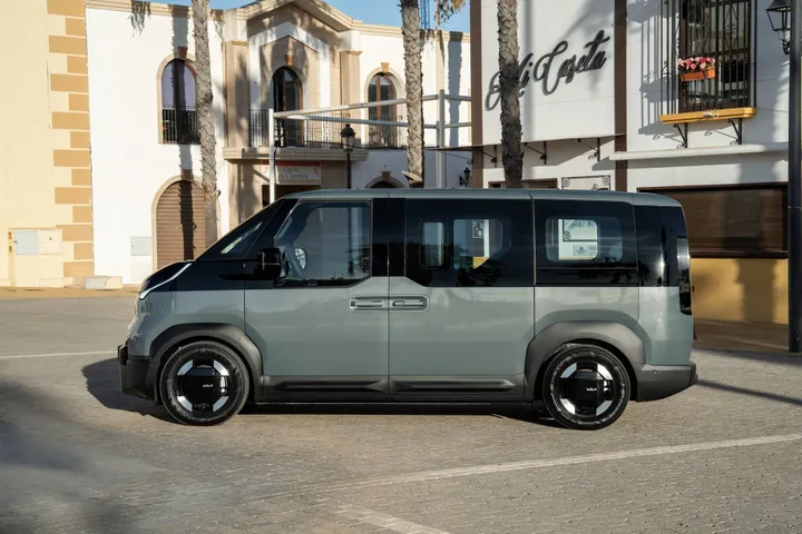 La vista laterale della Kia PV5 in colorazione bicolore grigia e nera