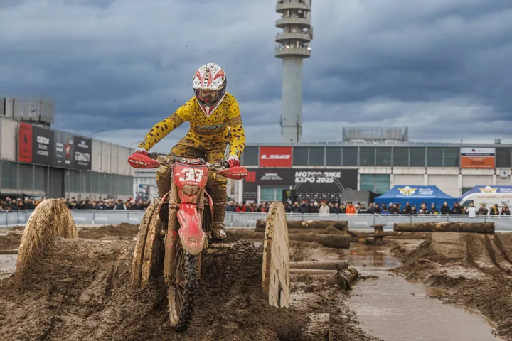 moto da cross che compie evoluzioni sul fango