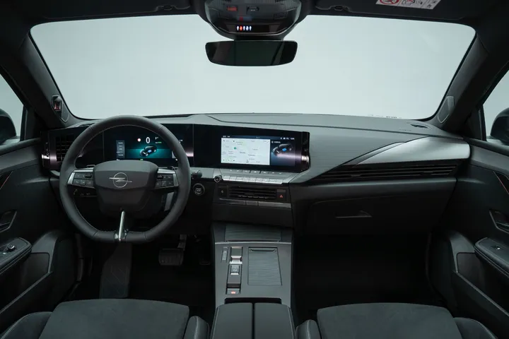 Gli interni della rinnovata Opel Astra 2026, con il nuovo logo Opel sul volante, materiali riciclati e pelle di origine vegetale.